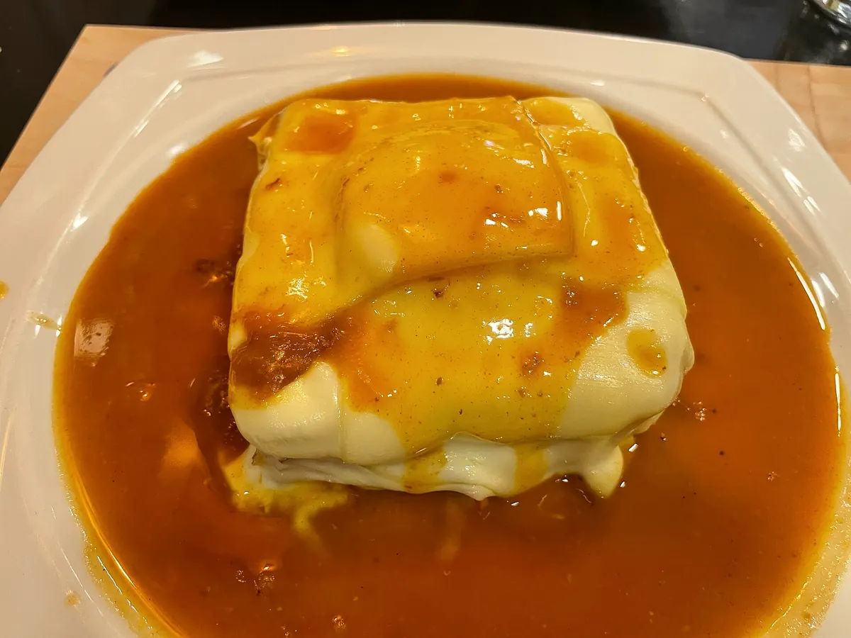 A francesinha sandwich in its beer-and-tomato sauce