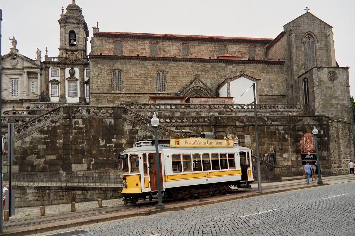 Heritage tram in front of a granite church in Porto